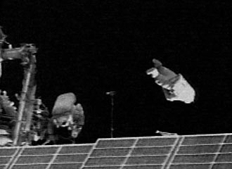 Spacewalkers release the SuitSat (right center), an old Russian spacesuit with an amateur radio transmitter.